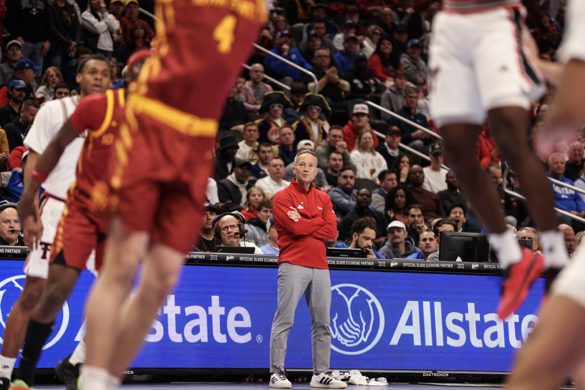 Coach framed between players — Big 12 Tournament